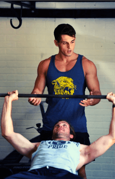 Personal trainer spotting a client during bench press at Tiger ATX Training in Austin, TX